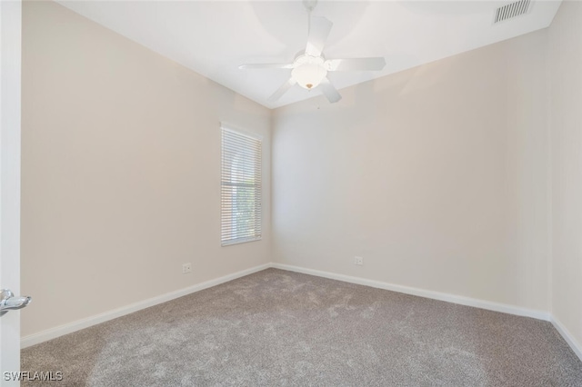 empty room with a ceiling fan, light colored carpet, visible vents, and baseboards