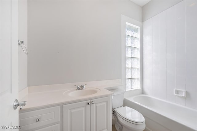 bathroom with a bathtub, a healthy amount of sunlight, vanity, and toilet