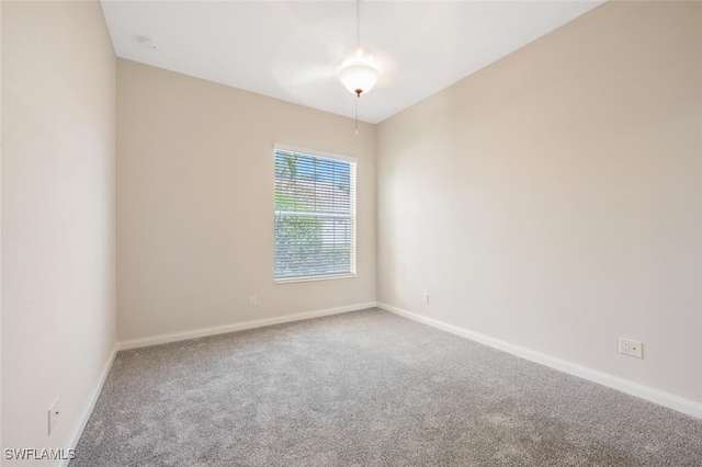 spare room featuring carpet flooring and baseboards