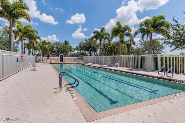 community pool featuring fence and a patio