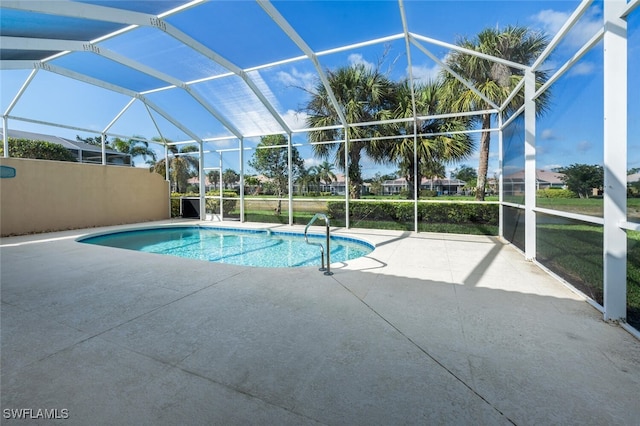 outdoor pool with glass enclosure and a patio