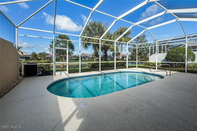 outdoor pool featuring glass enclosure and a patio area