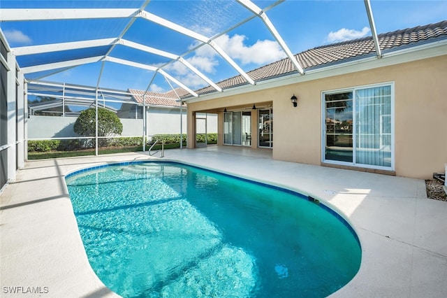 pool with glass enclosure and a patio area