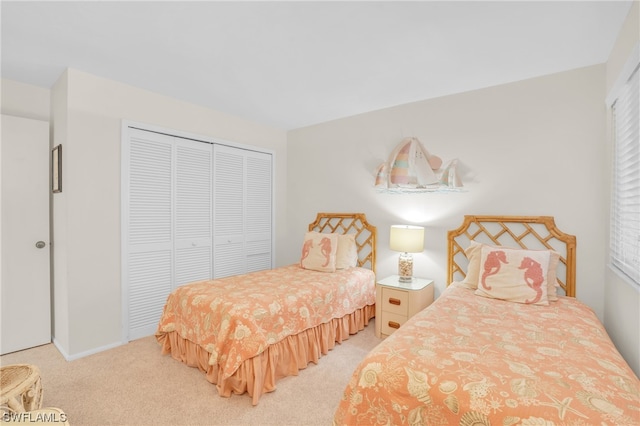 bedroom featuring light colored carpet and a closet