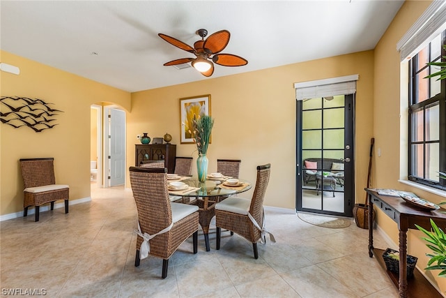 dining room featuring light tile floors, ceiling fan, and a wealth of natural light