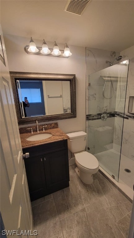 bathroom featuring a shower with door, vanity with extensive cabinet space, tile flooring, and toilet