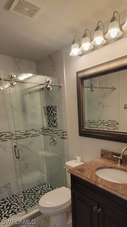 bathroom with toilet, a shower with door, and vanity