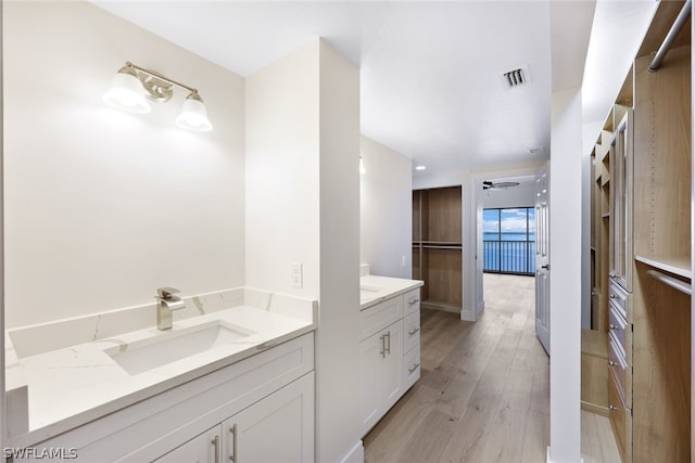 bathroom with hardwood / wood-style floors, ceiling fan, and vanity