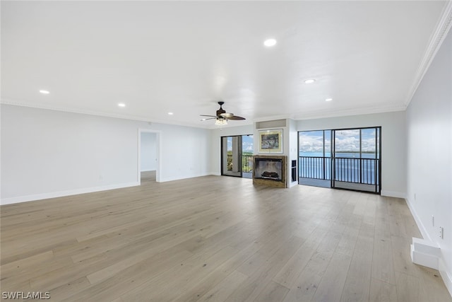 unfurnished living room featuring light wood-type flooring, ceiling fan, and ornamental molding