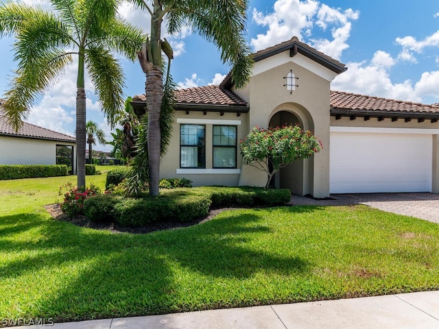 mediterranean / spanish-style home featuring a front yard and a garage