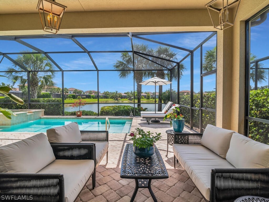 exterior space featuring outdoor lounge area, a jacuzzi, a water view, glass enclosure, and a patio