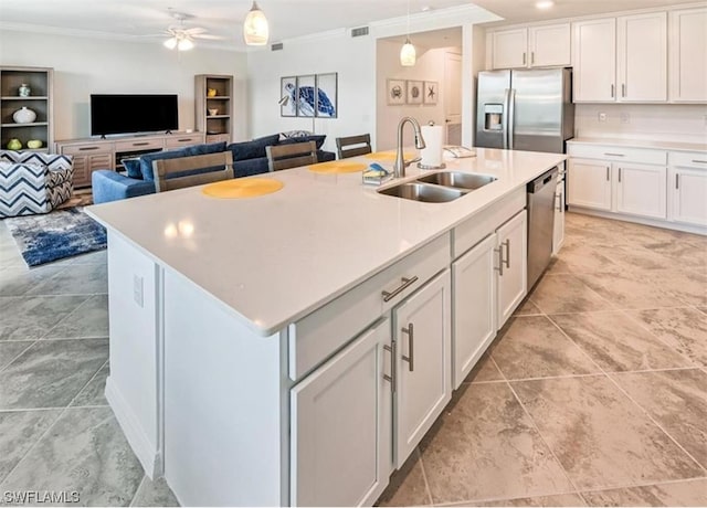 kitchen with ceiling fan, hanging light fixtures, a center island with sink, stainless steel appliances, and light tile flooring