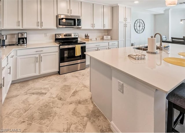 kitchen with light tile flooring, white cabinets, appliances with stainless steel finishes, and sink