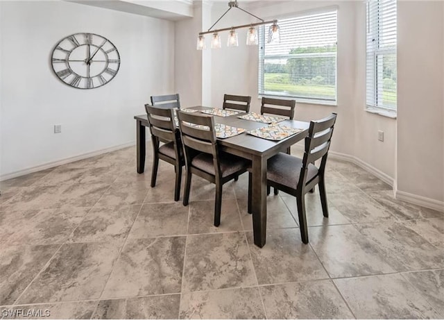 tiled dining space with an inviting chandelier