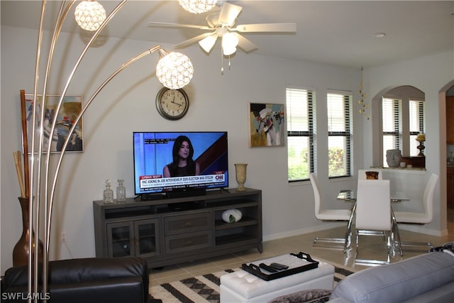 living room featuring light tile floors and ceiling fan with notable chandelier