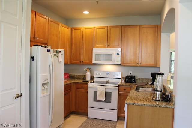 kitchen with white appliances, sink, light tile floors, and light stone counters