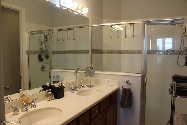 bathroom featuring walk in shower and double vanity