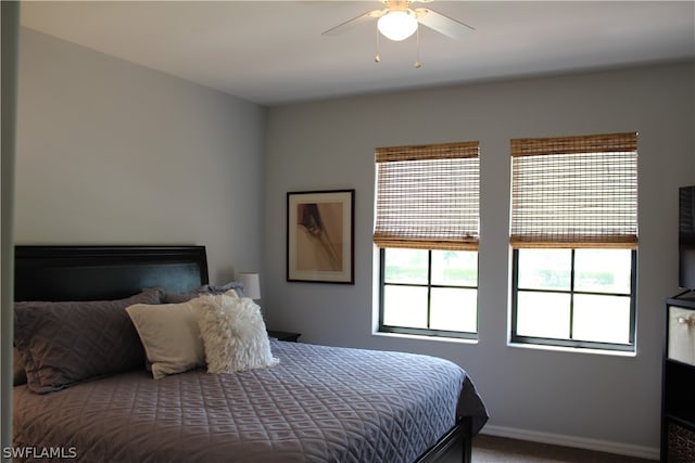 bedroom with ceiling fan and dark carpet