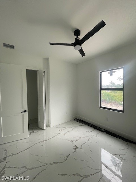 tiled empty room featuring ceiling fan