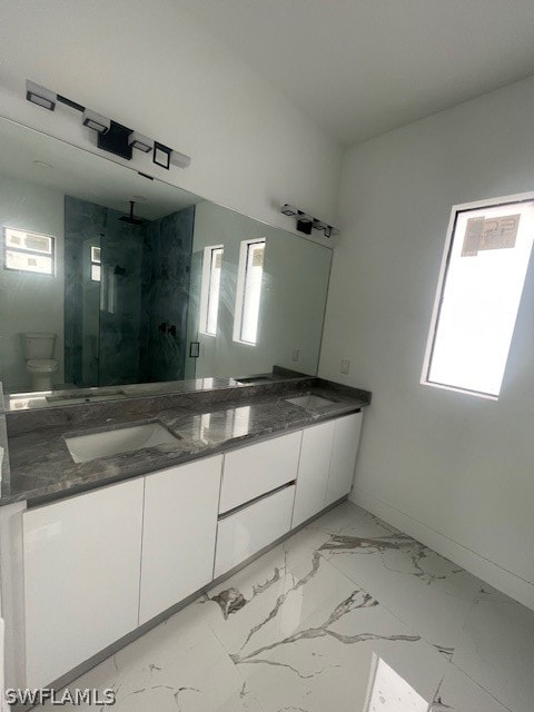 bathroom featuring double vanity, tile patterned floors, toilet, and a wealth of natural light