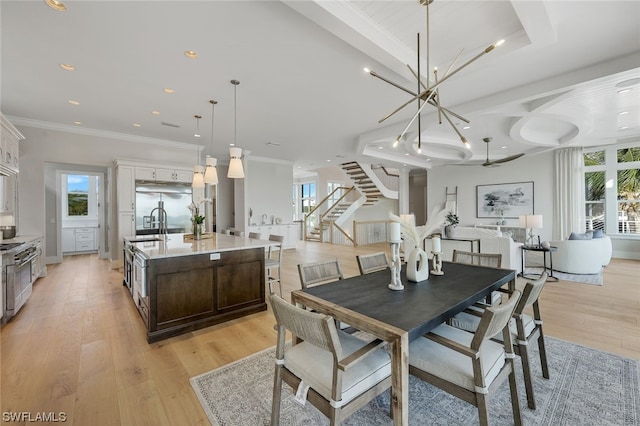 dining area with an inviting chandelier, crown molding, and light hardwood / wood-style flooring