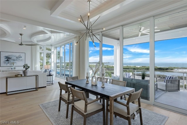 sunroom featuring a raised ceiling, a water view, wooden ceiling, and a chandelier