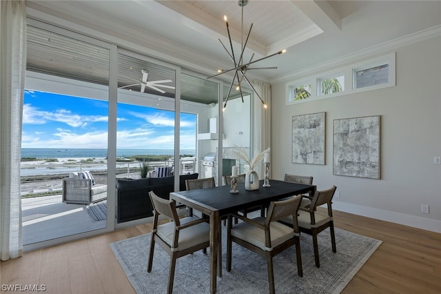 dining space featuring crown molding, light wood-style flooring, and baseboards