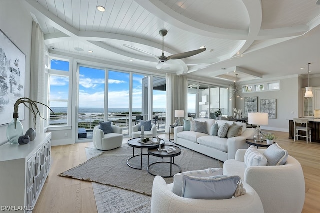 living room featuring ceiling fan, crown molding, beam ceiling, a water view, and light hardwood / wood-style flooring