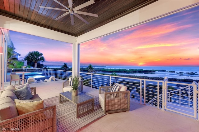 patio terrace at dusk featuring ceiling fan, a balcony, and an outdoor hangout area