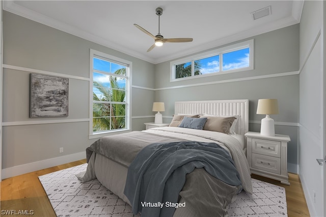 bedroom featuring ceiling fan, light hardwood / wood-style floors, and crown molding