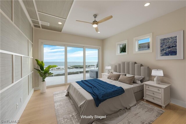 bedroom featuring ceiling fan, a water view, light wood-type flooring, and access to outside