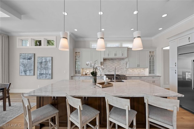 kitchen featuring built in fridge, pendant lighting, and a spacious island