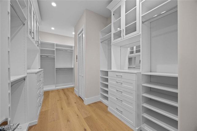 walk in closet with light hardwood / wood-style floors