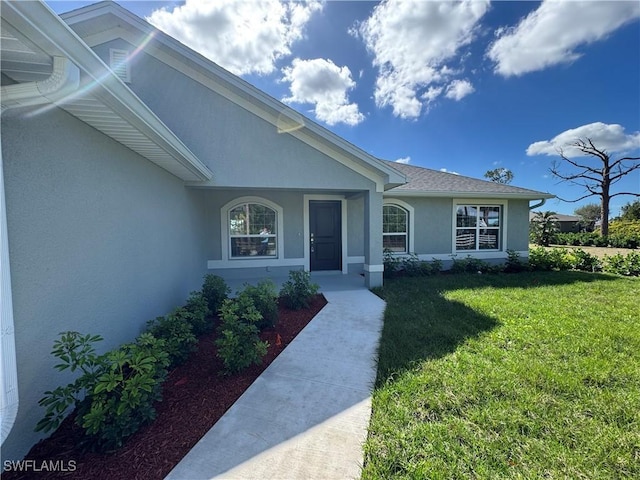 property entrance with a lawn