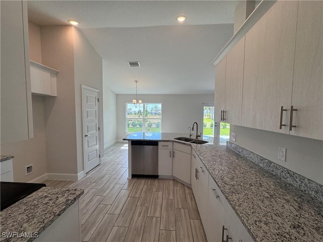 kitchen with decorative light fixtures, dishwasher, sink, kitchen peninsula, and light stone countertops