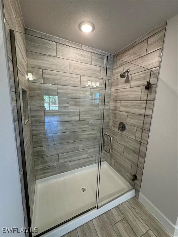 bathroom with a textured ceiling and walk in shower