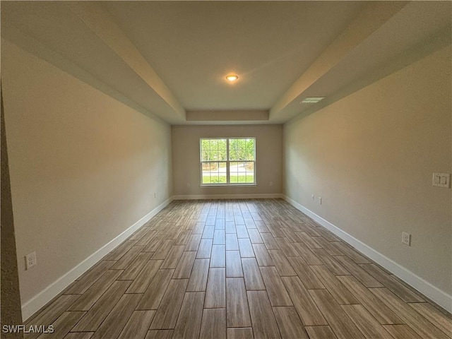 unfurnished room with a tray ceiling