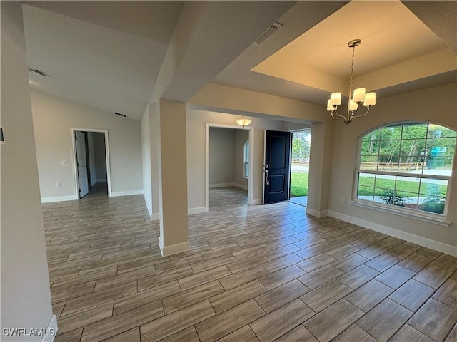 spare room featuring an inviting chandelier and a tray ceiling