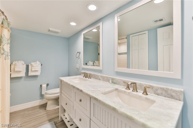 bathroom featuring tile floors, double vanity, and toilet