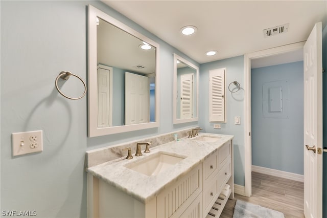 bathroom featuring double vanity and wood-type flooring