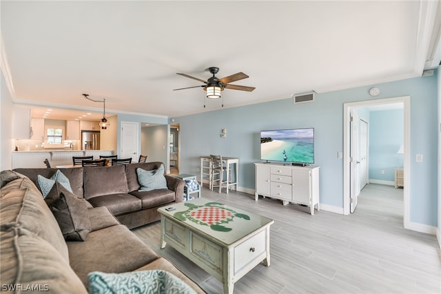 living room featuring crown molding and ceiling fan