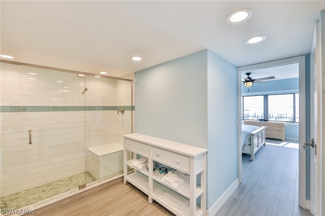 bathroom featuring ceiling fan and a shower with door