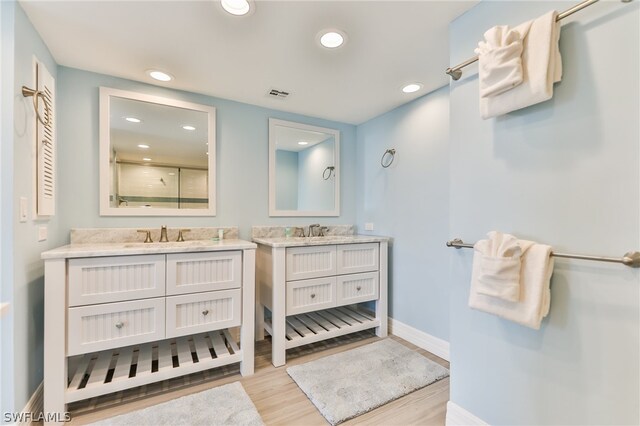 bathroom with double sink vanity and hardwood / wood-style flooring