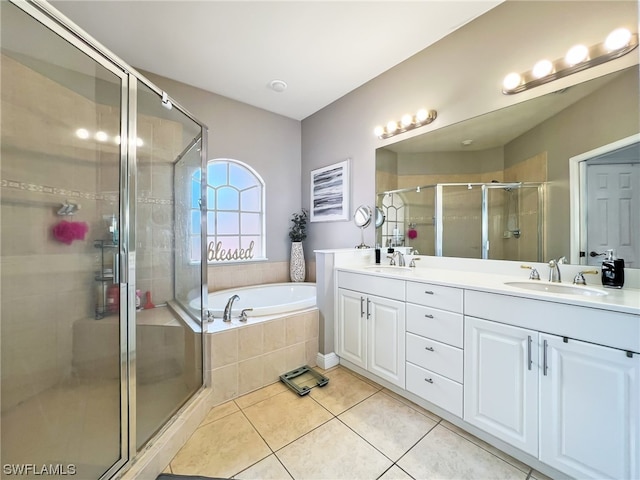 bathroom featuring independent shower and bath, tile flooring, vanity with extensive cabinet space, and dual sinks