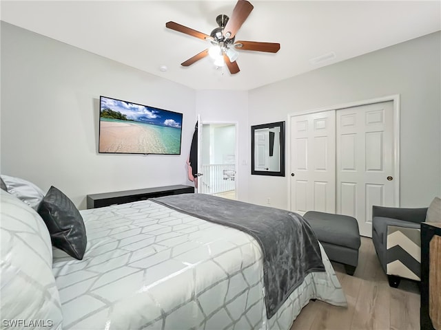 bedroom with a closet, light hardwood / wood-style floors, and ceiling fan