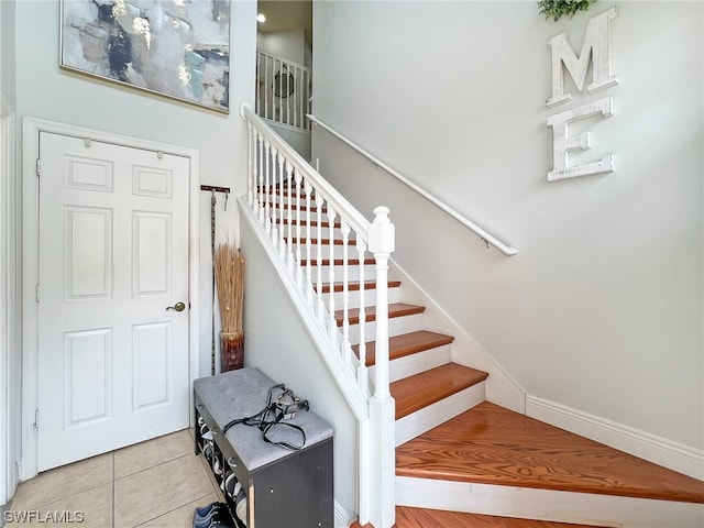 staircase featuring light tile floors