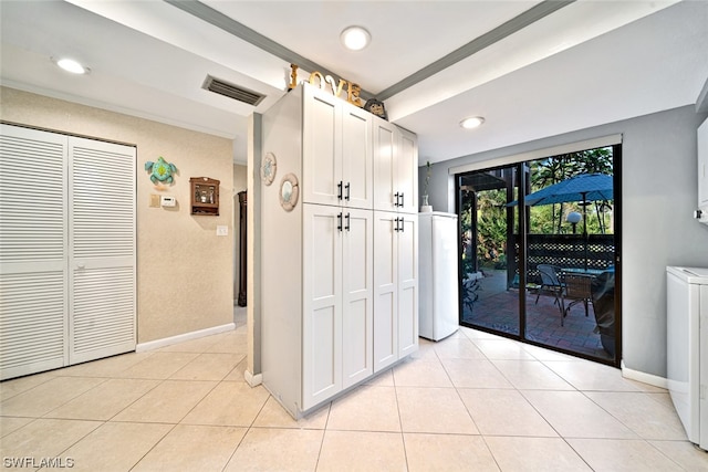 corridor with washer / clothes dryer and light tile patterned flooring