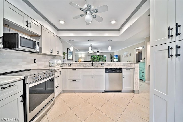 kitchen with sink, hanging light fixtures, stainless steel appliances, kitchen peninsula, and white cabinets