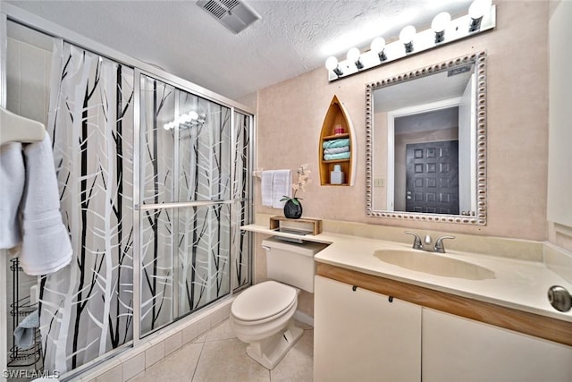 bathroom featuring tile patterned floors, vanity, a textured ceiling, a shower, and toilet