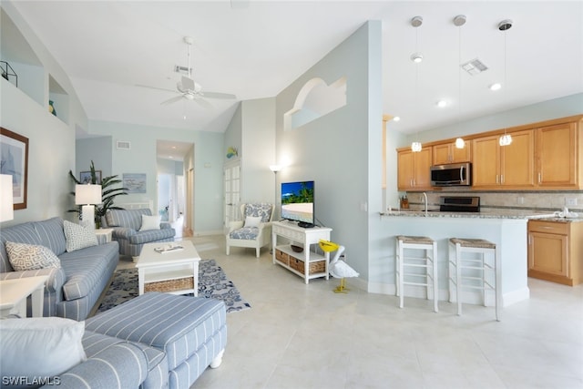 tiled living room featuring ceiling fan and sink